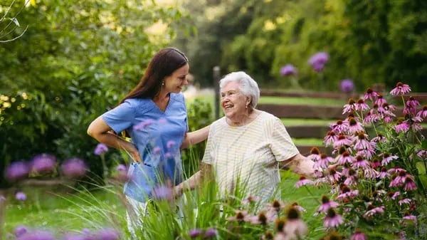 seasonal-caregiver-walking-senior-garden
